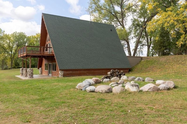 view of side of home featuring roof with shingles, a yard, a patio area, and a wooden deck