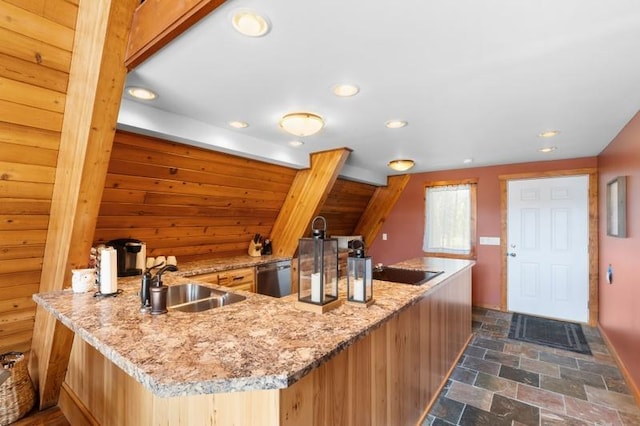 kitchen featuring light stone counters, stone finish flooring, recessed lighting, stainless steel dishwasher, and a sink