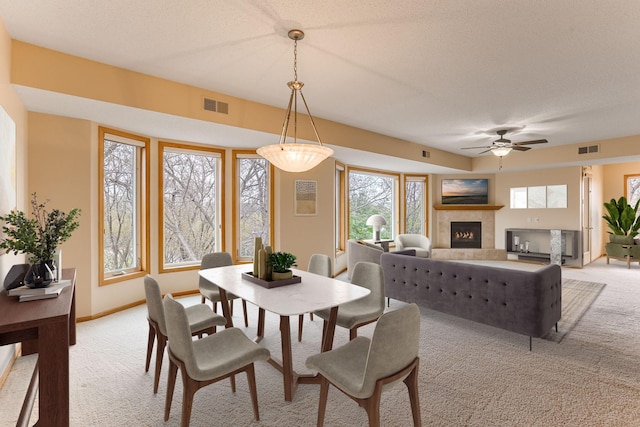 dining area featuring visible vents, a ceiling fan, a wealth of natural light, and light carpet