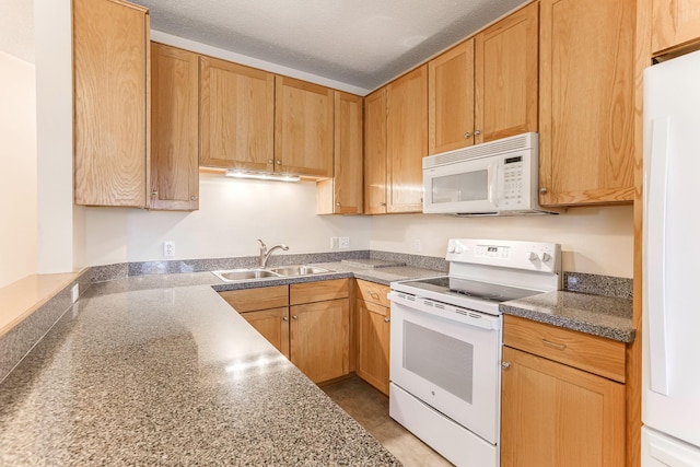 kitchen with a sink, white appliances, and a textured ceiling