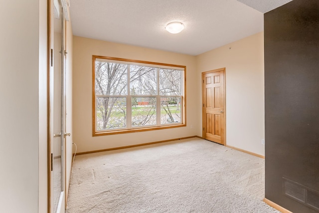 carpeted empty room with baseboards and visible vents