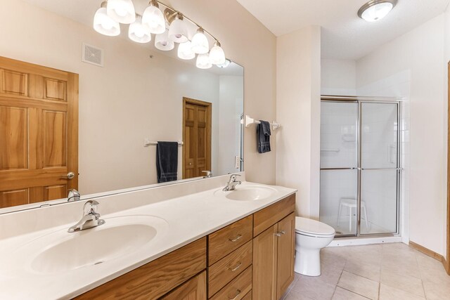 bathroom featuring tile patterned flooring, a sink, a stall shower, and visible vents