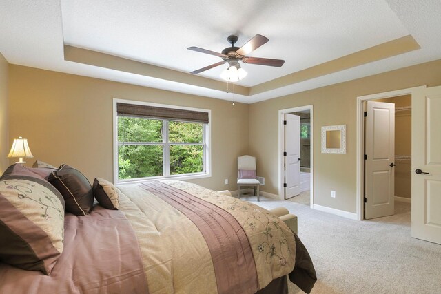 12566 Xylite St NE, Blaine, MN 55449 - bedroom with a tray ceiling, light colored carpet, baseboards, a ceiling fan, and a spacious closet