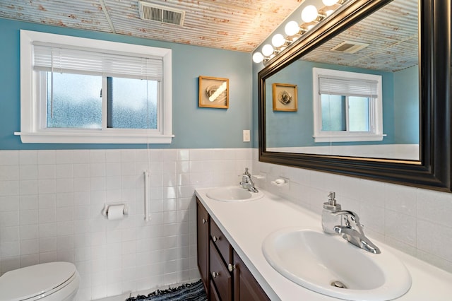12329 Timber Ln, Maple Grove, MN 55369 - full bathroom with tile walls, wooden ceiling, toilet, double vanity, and a wainscoted wall