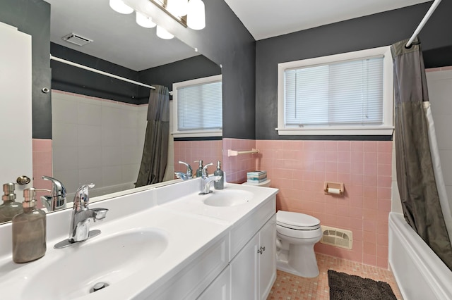 12329 Timber Ln, Maple Grove, MN 55369 - bathroom with tile walls, tile patterned floors, toilet, shower / bath combo with shower curtain, and a wainscoted wall
