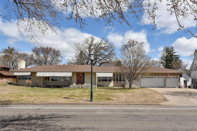 ranch-style house with an attached garage, concrete driveway, a front yard, and brick siding