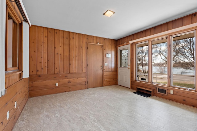 spare room featuring wooden walls