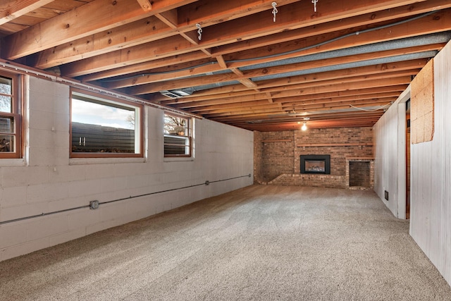 basement featuring a brick fireplace and carpet floors