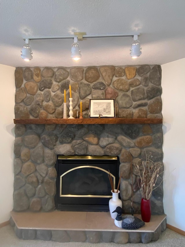 details with a stone fireplace and baseboards