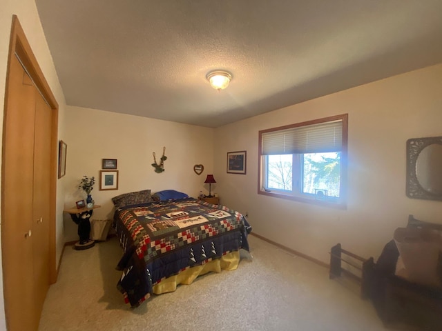 carpeted bedroom with baseboards and a textured ceiling