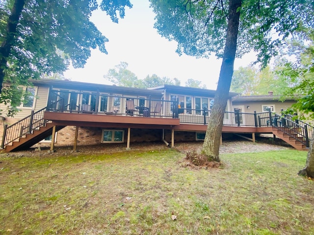 rear view of house with a wooden deck, a sunroom, stairs, and a yard