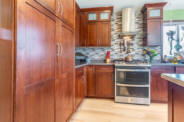 918 Division St, Elbow Lake, MN 56531 - kitchen with double oven range, wall chimney range hood, decorative backsplash, and glass insert cabinets