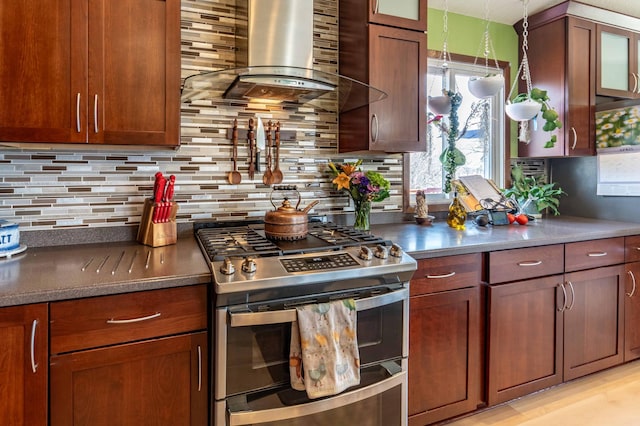 918 Division St, Elbow Lake, MN 56531 - kitchen featuring double oven range, wall chimney exhaust hood, healthy amount of natural light, and decorative backsplash