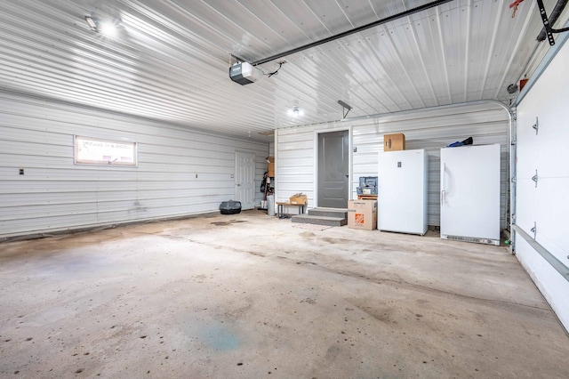 918 Division St, Elbow Lake, MN 56531 - garage with a garage door opener and freestanding refrigerator