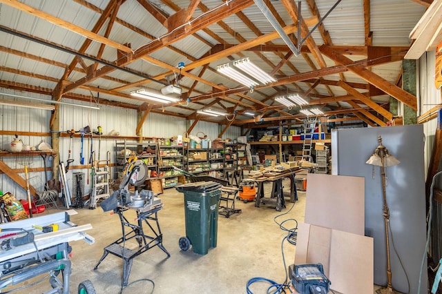 918 Division St, Elbow Lake, MN 56531 - garage with a garage door opener, refrigerator, a workshop area, and metal wall