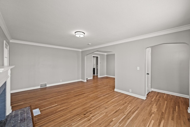 4240 Lake Road Ave, Robbinsdale, MN 55422 - unfurnished living room featuring wood finished floors, visible vents, arched walkways, crown molding, and baseboards