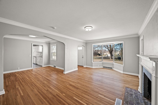 4240 Lake Road Ave, Robbinsdale, MN 55422 - unfurnished living room featuring arched walkways, wood finished floors, and visible vents
