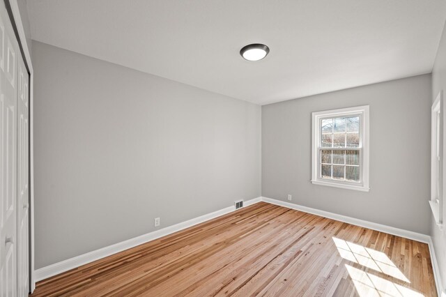 4240 Lake Road Ave, Robbinsdale, MN 55422 - unfurnished bedroom featuring baseboards, wood finished floors, visible vents, and a closet