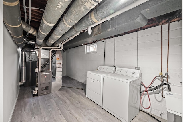 4240 Lake Road Ave, Robbinsdale, MN 55422 - washroom featuring washing machine and dryer, light wood-style floors, water heater, and laundry area
