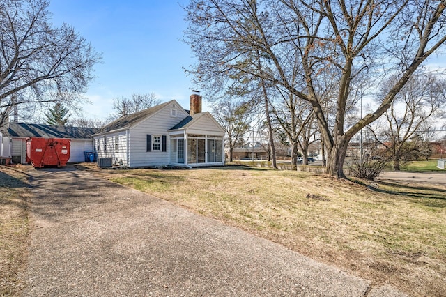 4240 Lake Road Ave, Robbinsdale, MN 55422 - exterior space with central air condition unit, a chimney, a yard, a sunroom, and aphalt driveway