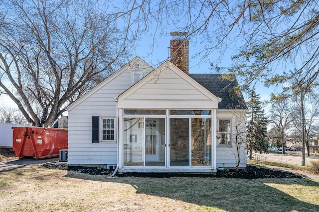 4240 Lake Road Ave, Robbinsdale, MN 55422 - back of house featuring cooling unit, a sunroom, a shingled roof, and a lawn