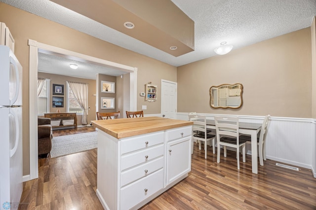 804 8th St N Unit 2, Fargo, ND 58102 - kitchen with freestanding refrigerator, wood finished floors, white cabinetry, butcher block countertops, and a textured ceiling