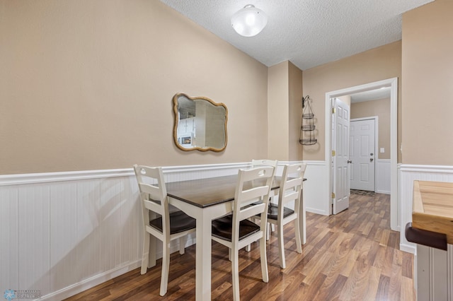 804 8th St N Unit 2, Fargo, ND 58102 - dining area with a textured ceiling, light wood finished floors, and wainscoting