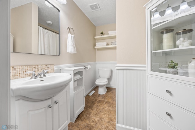 804 8th St N Unit 2, Fargo, ND 58102 - full bathroom with vanity, wainscoting, a textured ceiling, curtained shower, and tile patterned flooring