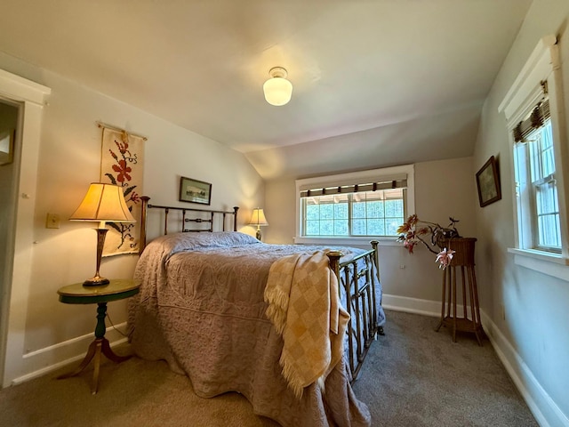 carpeted bedroom with baseboards and lofted ceiling