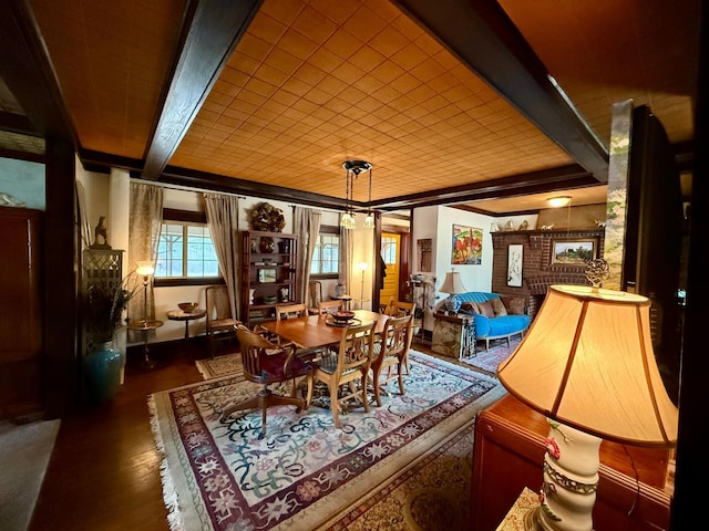 dining area with wood finished floors and beamed ceiling