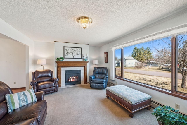 carpeted living area featuring a textured ceiling, baseboard heating, and a lit fireplace