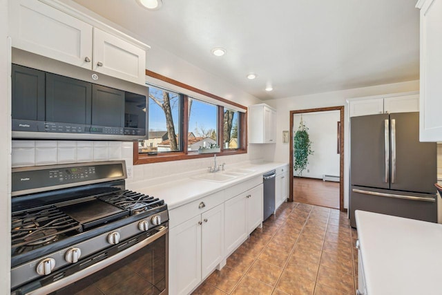 kitchen featuring a sink, recessed lighting, white cabinetry, light countertops, and appliances with stainless steel finishes