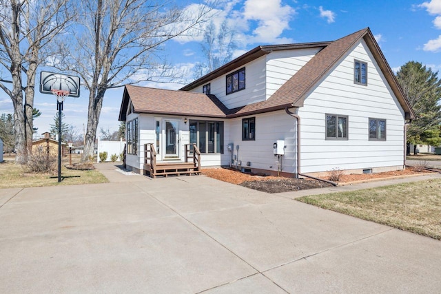 rear view of house featuring crawl space, driveway, and a shingled roof
