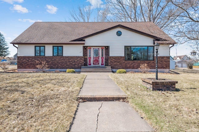ranch-style home with a front lawn, brick siding, and roof with shingles