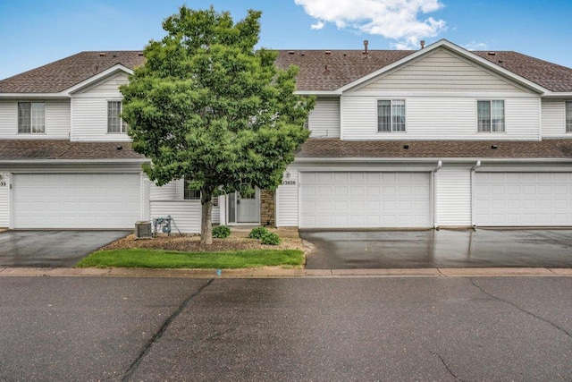 12626 43rd St NE, Saint Michael, MN 55376 - view of front of house with a shingled roof, a garage, driveway, and central air condition unit