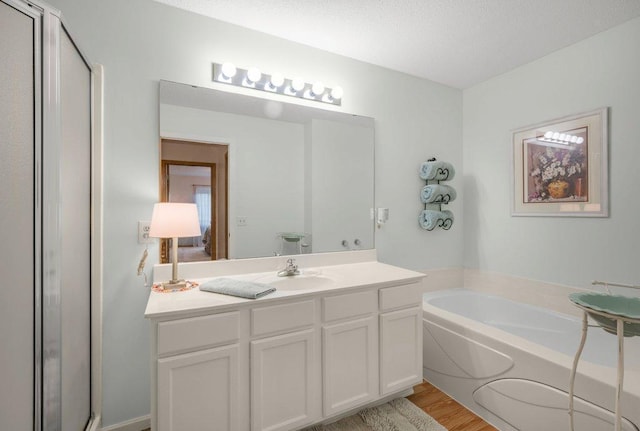 12626 43rd St NE, Saint Michael, MN 55376 - bathroom with a garden tub, vanity, a shower stall, and wood finished floors