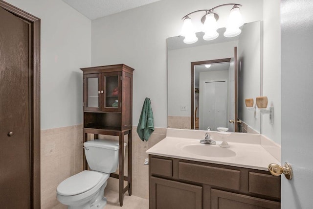 12626 43rd St NE, Saint Michael, MN 55376 - bathroom featuring tile walls, toilet, vanity, and a wainscoted wall
