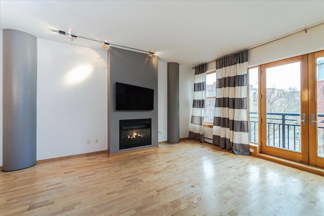 401 2nd St N Unit 220, Minneapolis, MN 55401 - unfurnished living room featuring a glass covered fireplace, light wood finished floors, and french doors
