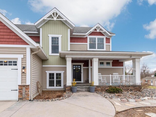 11460 Eagle Creek Ln, Rogers, MN 55374 - craftsman-style house with a porch, board and batten siding, a garage, and a shingled roof