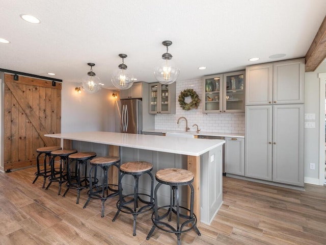 11460 Eagle Creek Ln, Rogers, MN 55374 - kitchen featuring freestanding refrigerator, gray cabinets, light wood-style floors, recessed lighting, and a spacious island