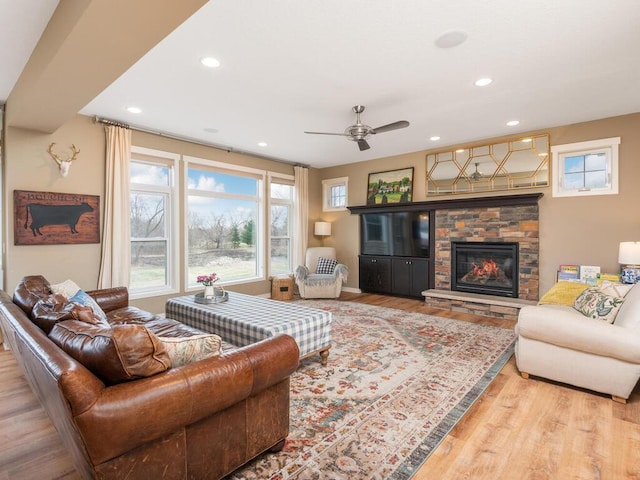 11460 Eagle Creek Ln, Rogers, MN 55374 - living room with wood finished floors, healthy amount of natural light, ceiling fan, a stone fireplace, and recessed lighting