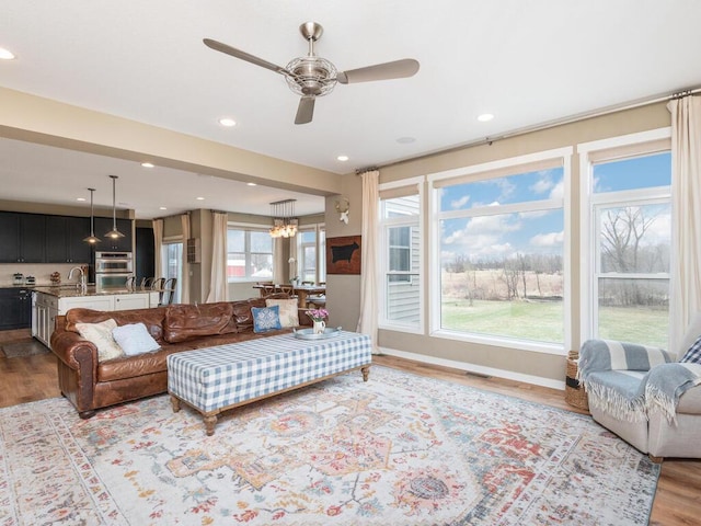 11460 Eagle Creek Ln, Rogers, MN 55374 - living area with wood finished floors, a ceiling fan, recessed lighting, and a chandelier