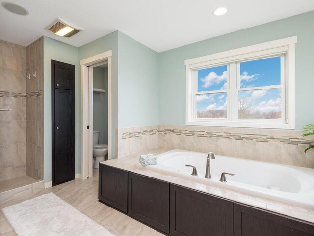 11460 Eagle Creek Ln, Rogers, MN 55374 - bathroom with a bath, toilet, a tile shower, and recessed lighting