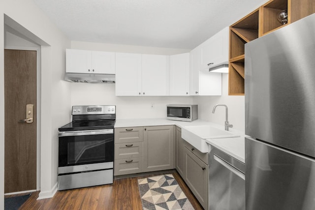 kitchen featuring open shelves, a sink, appliances with stainless steel finishes, under cabinet range hood, and dark wood-style floors