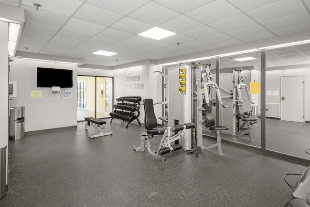 workout area with baseboards and a paneled ceiling