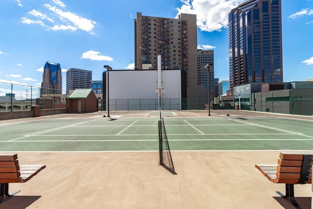 view of sport court featuring community basketball court, a view of city, and fence