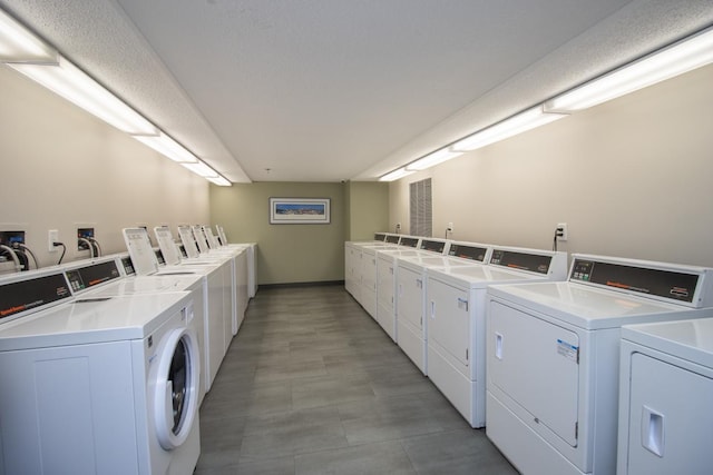 shared laundry area featuring washing machine and clothes dryer and baseboards