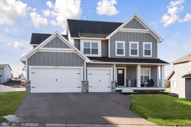 17917 Hayes Ave, Lakeville, MN 55044 - craftsman-style house with board and batten siding, a porch, a front lawn, and aphalt driveway