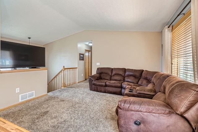 living area featuring carpet flooring, visible vents, and vaulted ceiling