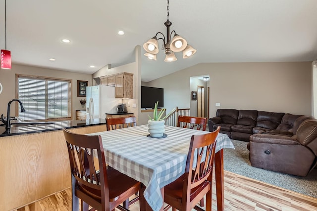 dining area featuring recessed lighting, a notable chandelier, lofted ceiling, and light wood-type flooring
